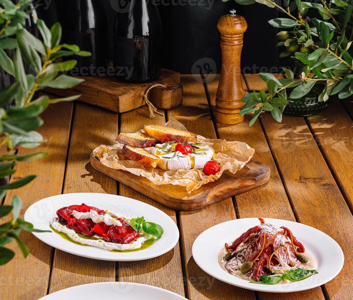 Variety of delicious bruschetta on rustic wooden table with wine and fresh ingredients photo