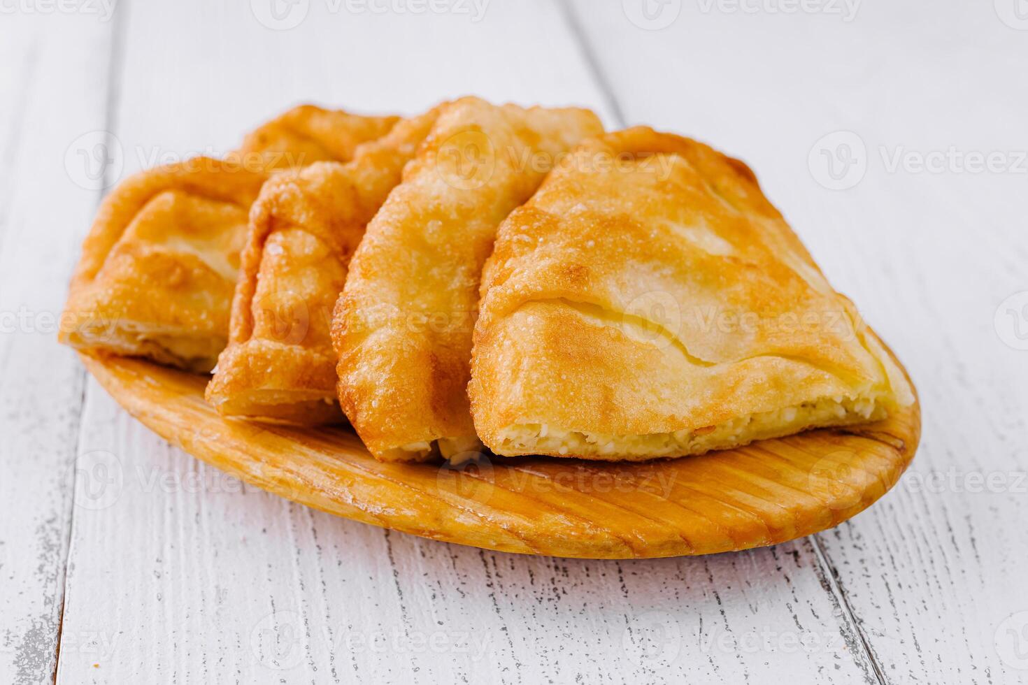 Freshly baked langos, savoury deep fried flat bread on wooden plate photo