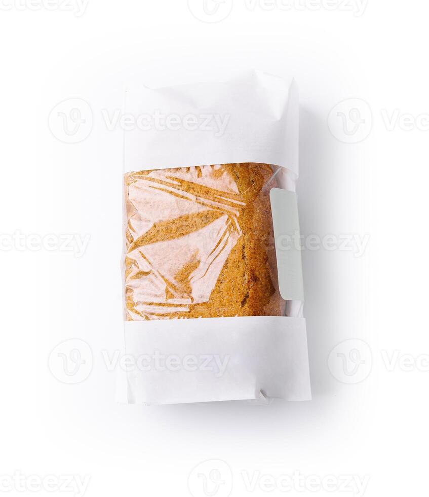 Freshly baked loaf of bread in minimalist packaging on white background photo