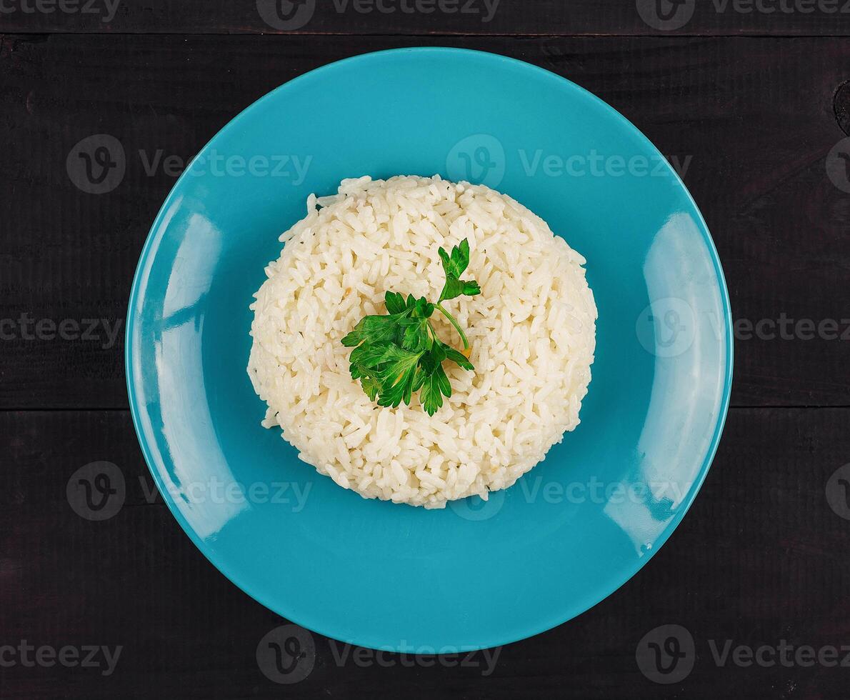 Plate of rice on a wooden table with garnish photo