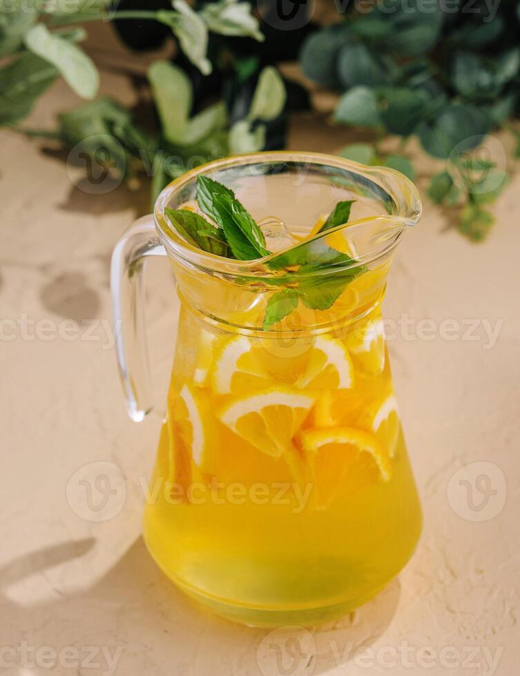Fresh citrus lemonade in glass pitcher with mint photo