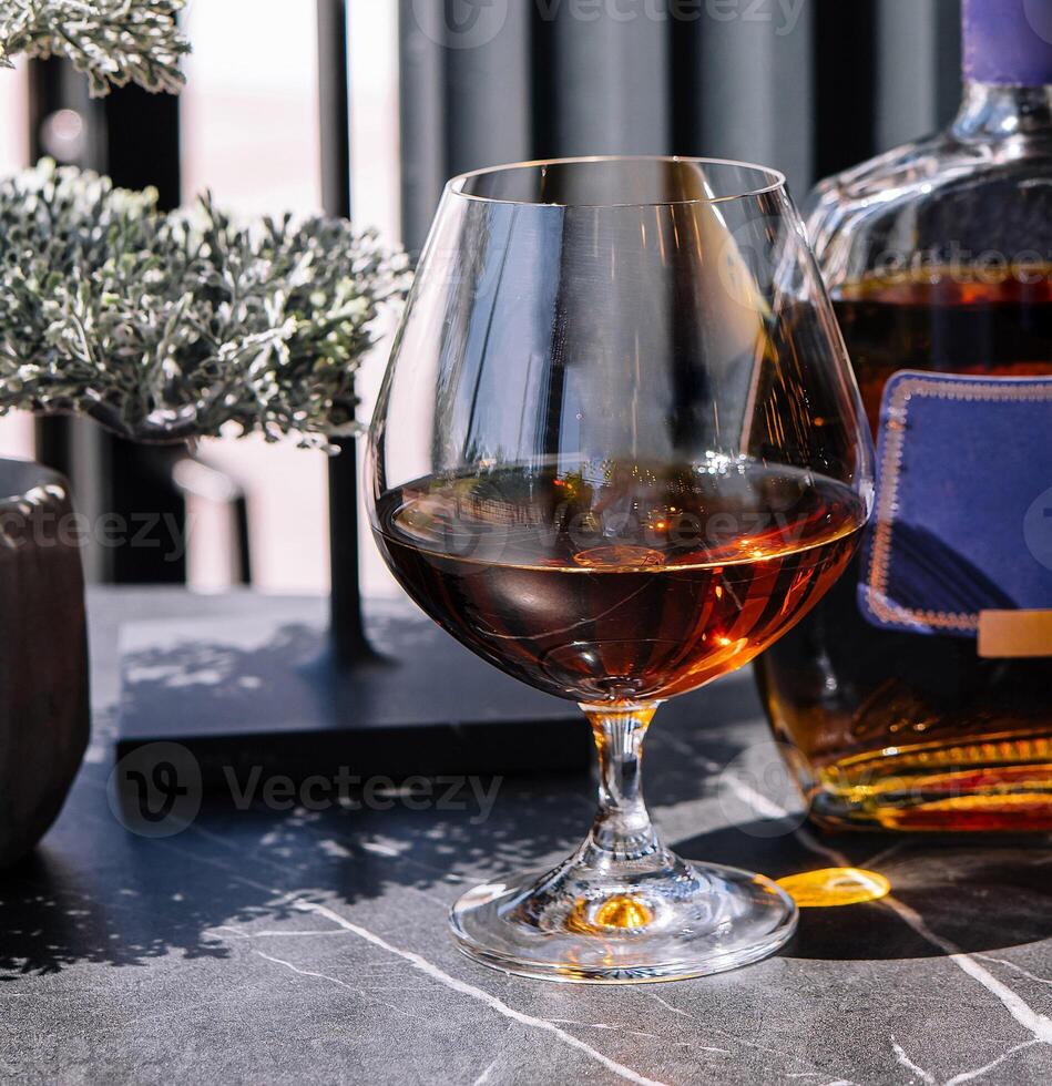 Elegant cognac pour with bottle on classy bar counter photo