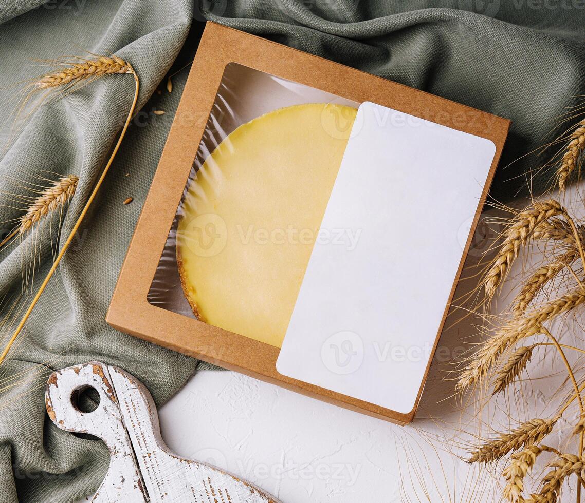 Artisan cheese wheel in craft packaging on rustic table photo
