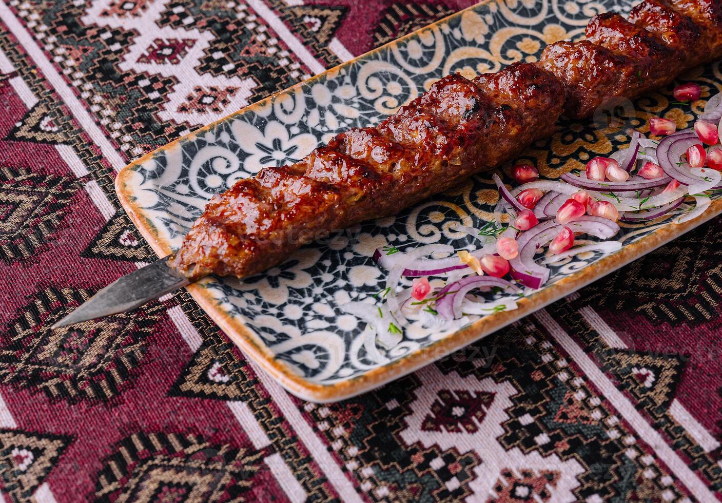 Savory grilled kebab on ornate ceramic plate photo