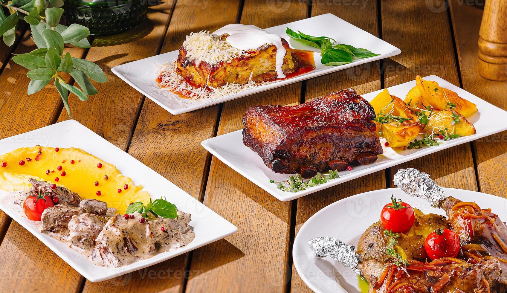 Gourmet feast - variety of dishes on wooden table photo