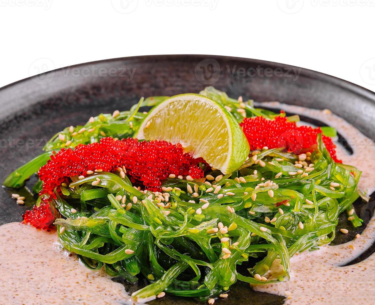 Fresh seaweed salad with tobiko garnish and lime photo