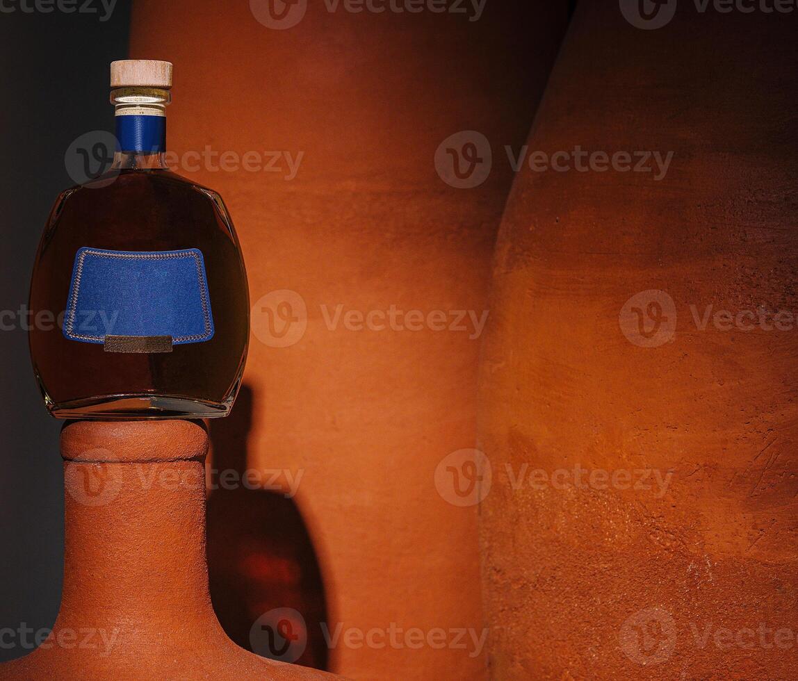 Artistic display of cognac bottle on clay sculpture photo