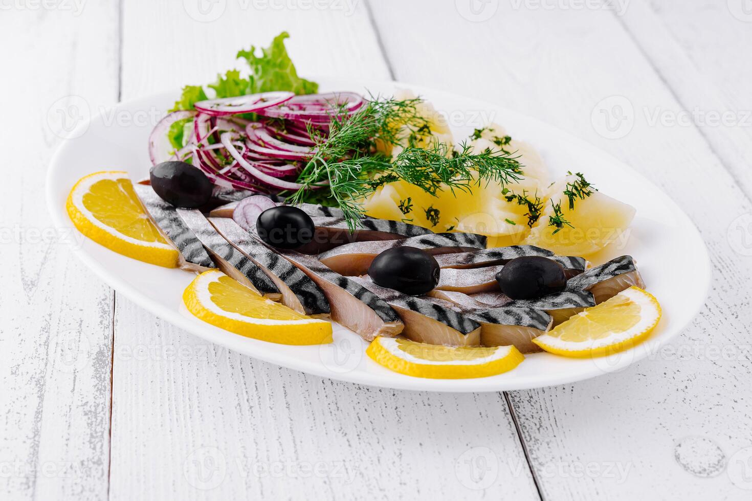 Sliced salted mackerel with potatoes and onions on white plate photo