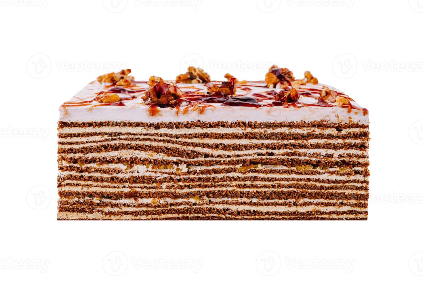 Delicious cake topped with walnuts and caramel drizzle on white background photo