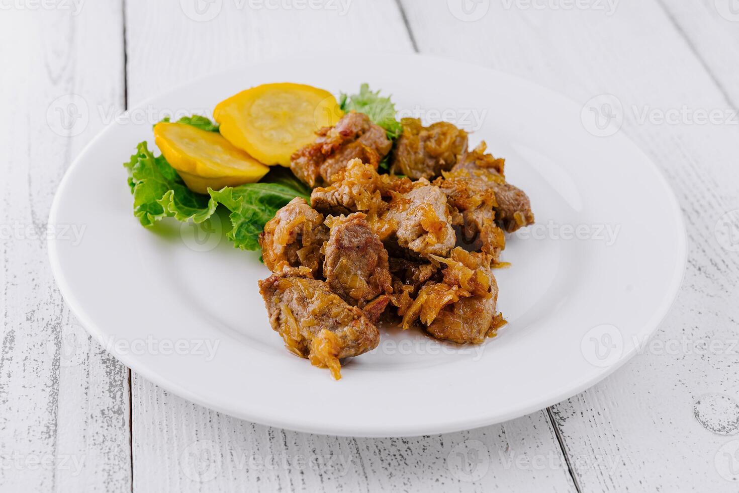 Delicious fried pork meat presenting on white plate with vegetable garnish photo
