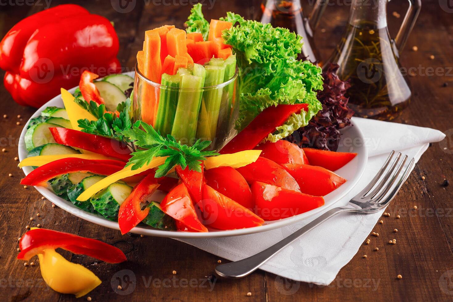 Vegetarian plate featuring carrot celery sticks and sliced bell peppers photo