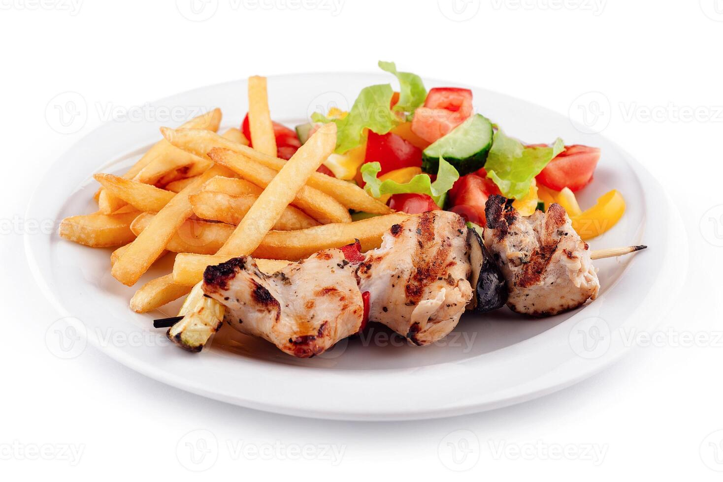 Chicken shish kebab plate being served with french fries and salad photo