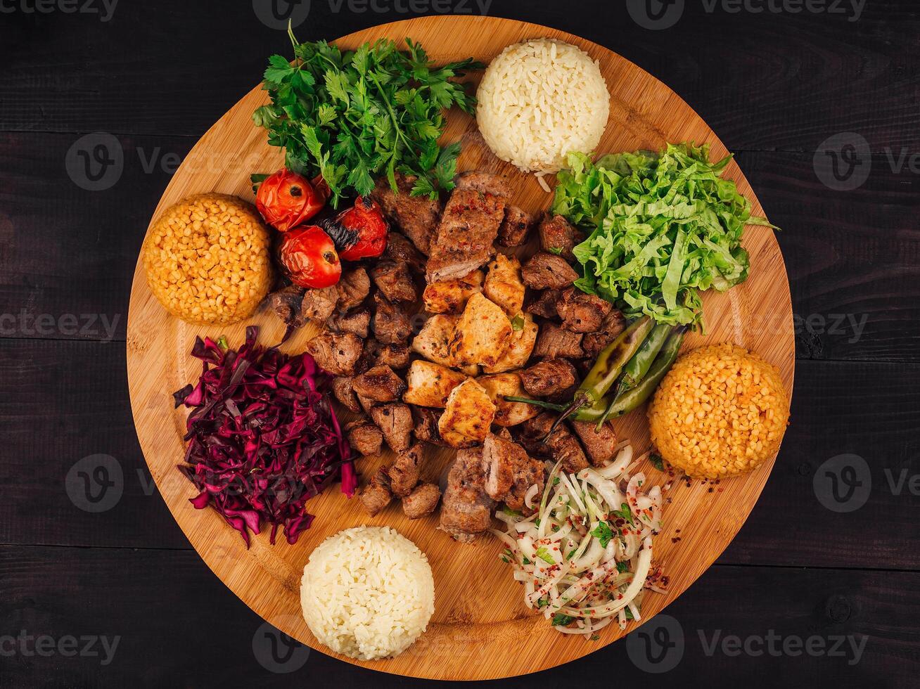 Turkish kebab serving with rice and vegetables on wooden plate photo