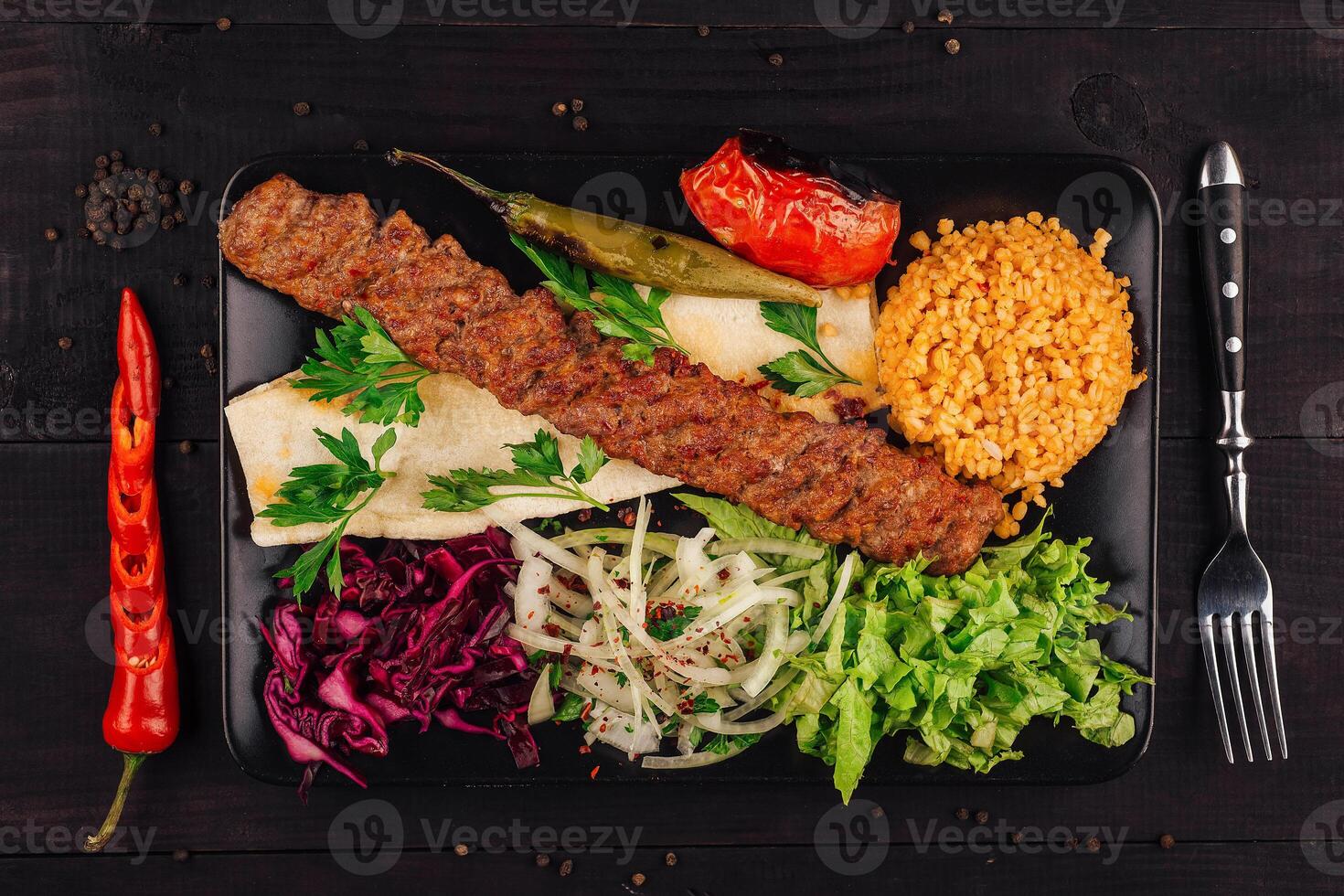 Traditional turkish adana kebab serving with vegetables and bulgur rice pilaf photo