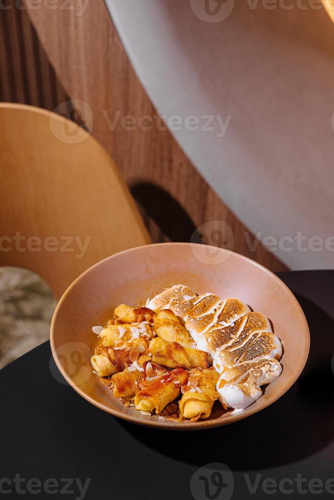Delicious rolled pancakes with toasted marshmallow and caramel sauce topping in restaurant photo