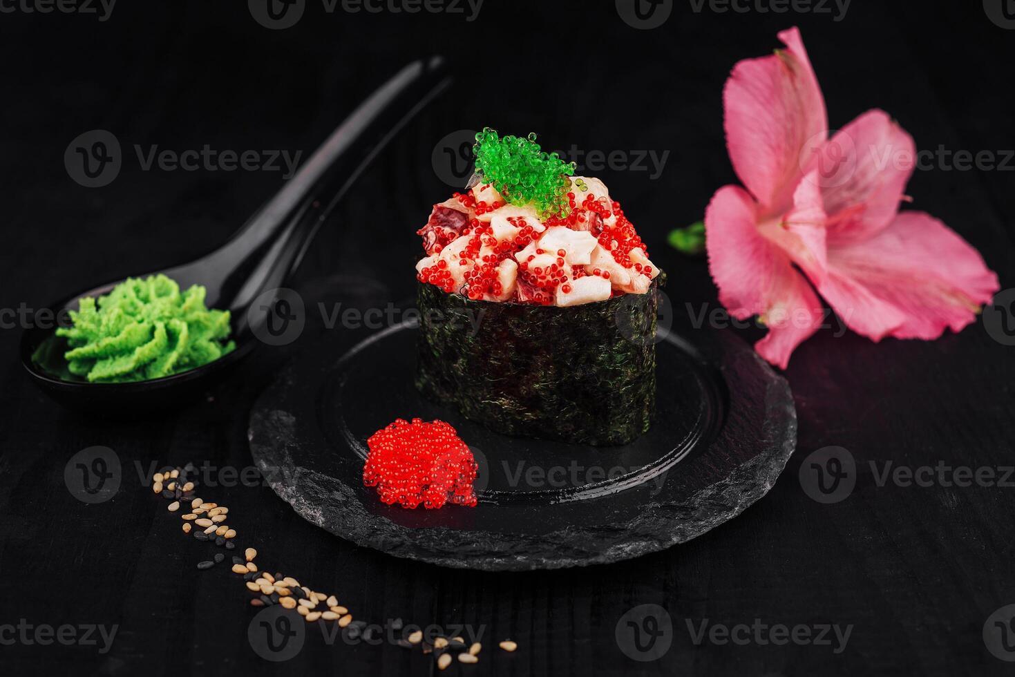 Gunkan maki sushi with tobiko and red caviar resting on a slate plate photo