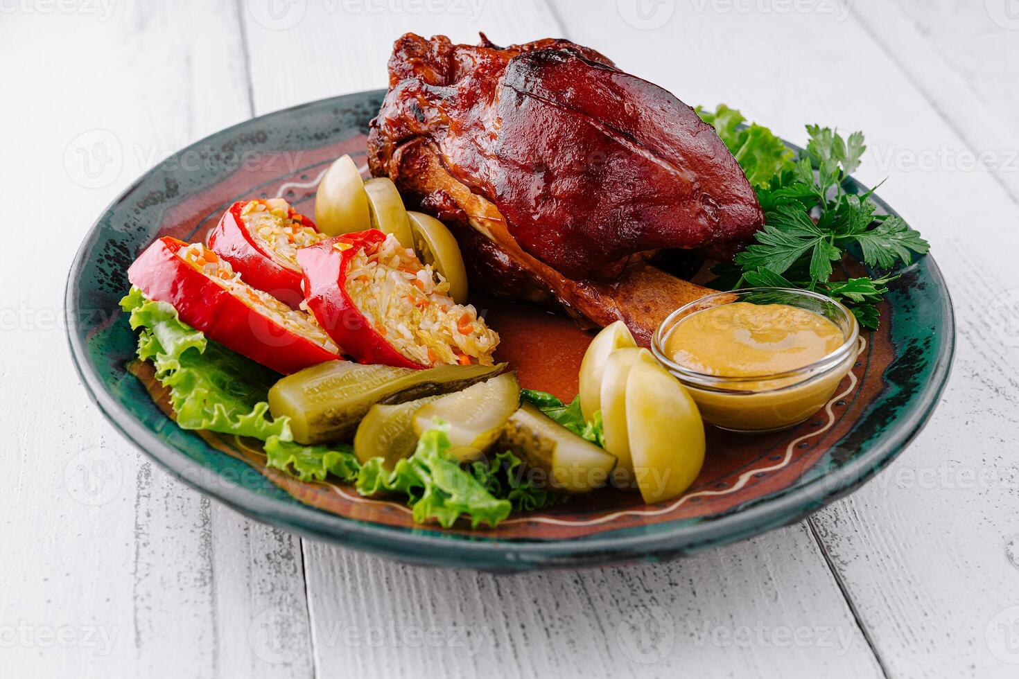 Roasted pork knuckle being served on plate with sauerkraut and mustard photo