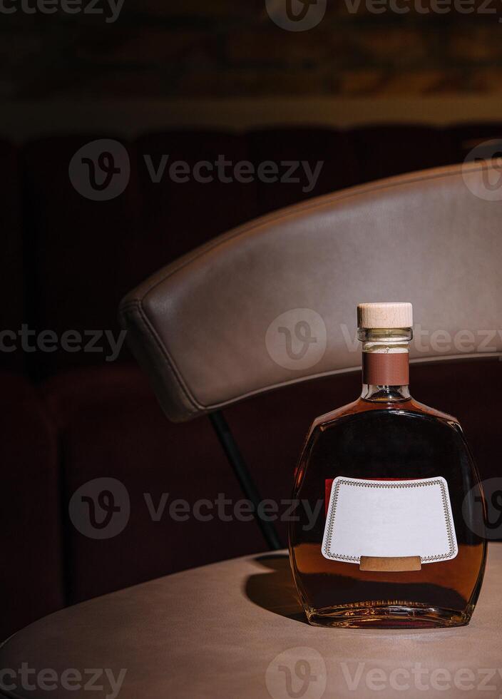 Bottle of cognac resting on a bar table in a nightclub photo