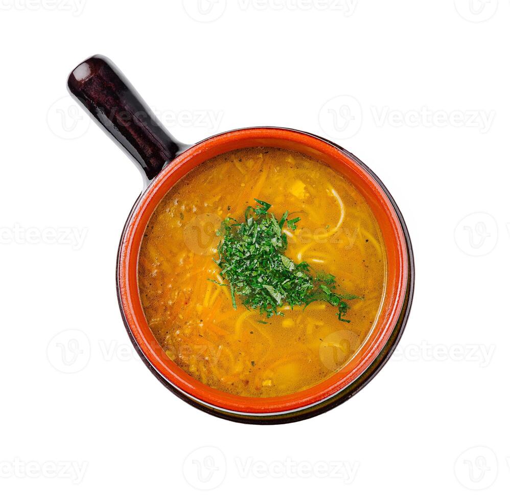 Chicken soup with noodles and carrots being served in a bowl photo