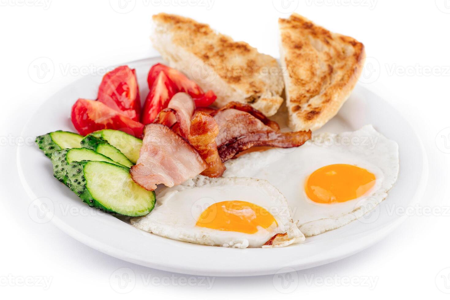 Delicious breakfast plate offering fried eggs and bacon with vegetables and toast photo