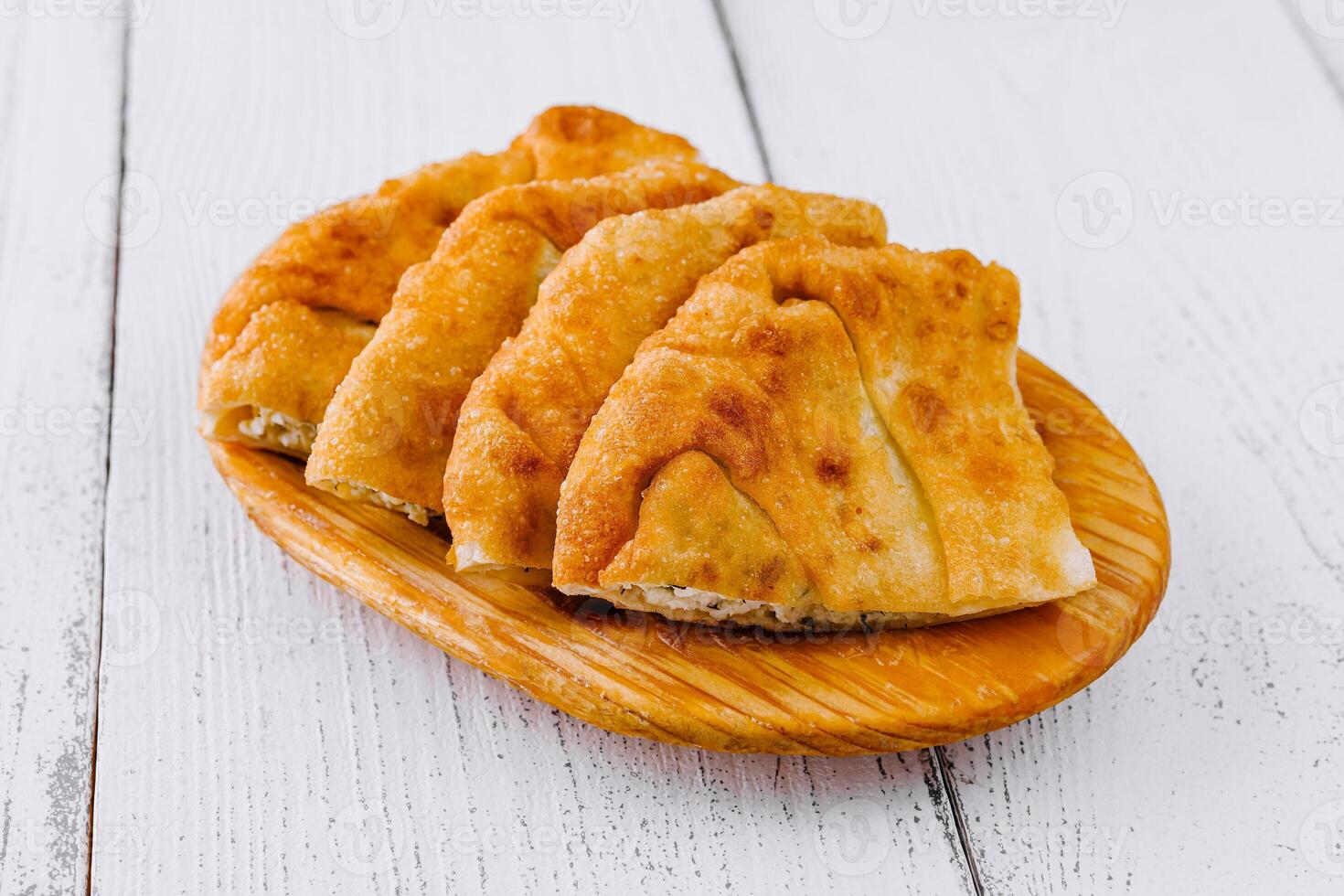 Traditional balkan pies with cheese filling resting on wooden plate photo