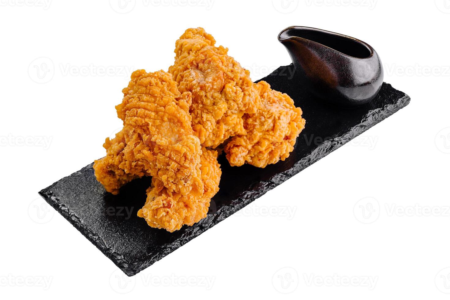 Fried chicken wings with dipping sauce on black stone plate photo