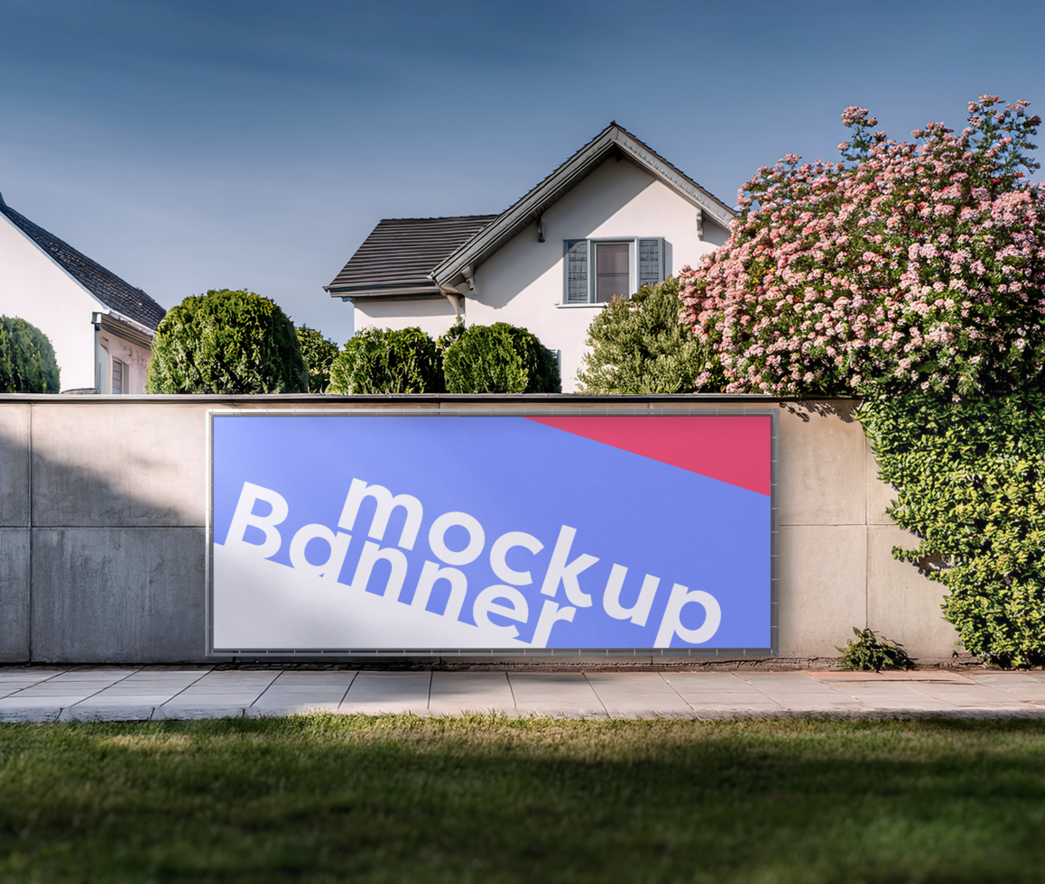 billboard mockup on wall, houses in the background, green grass in front, plants around the wall psd