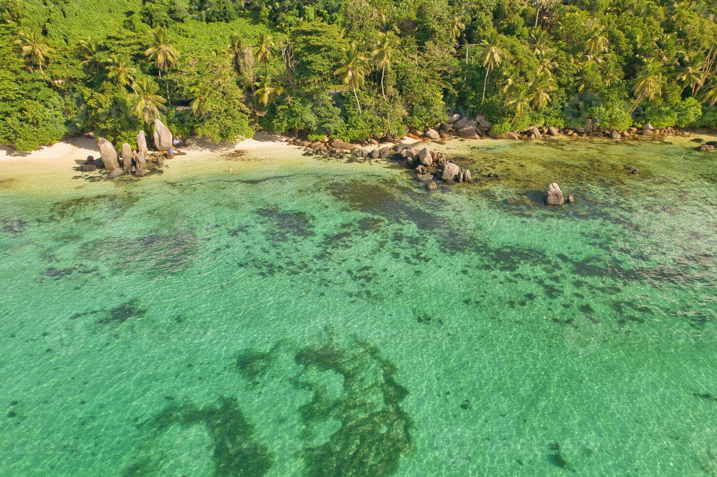 Drone aerial shot of Anse royale, fairy land of beautiful white sandy beach with granite stones and lush greenery, Mahe Seychelles photo