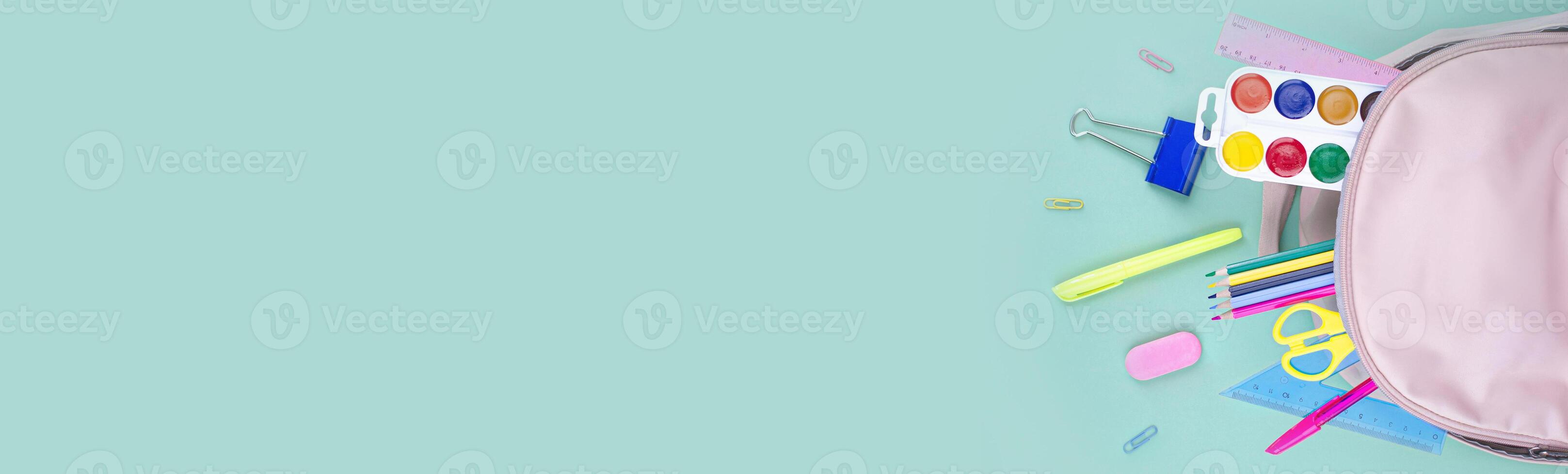 Back to school concept. School supplies in a backpack. Pastel colors flat lay horizontal long banner copy space photo