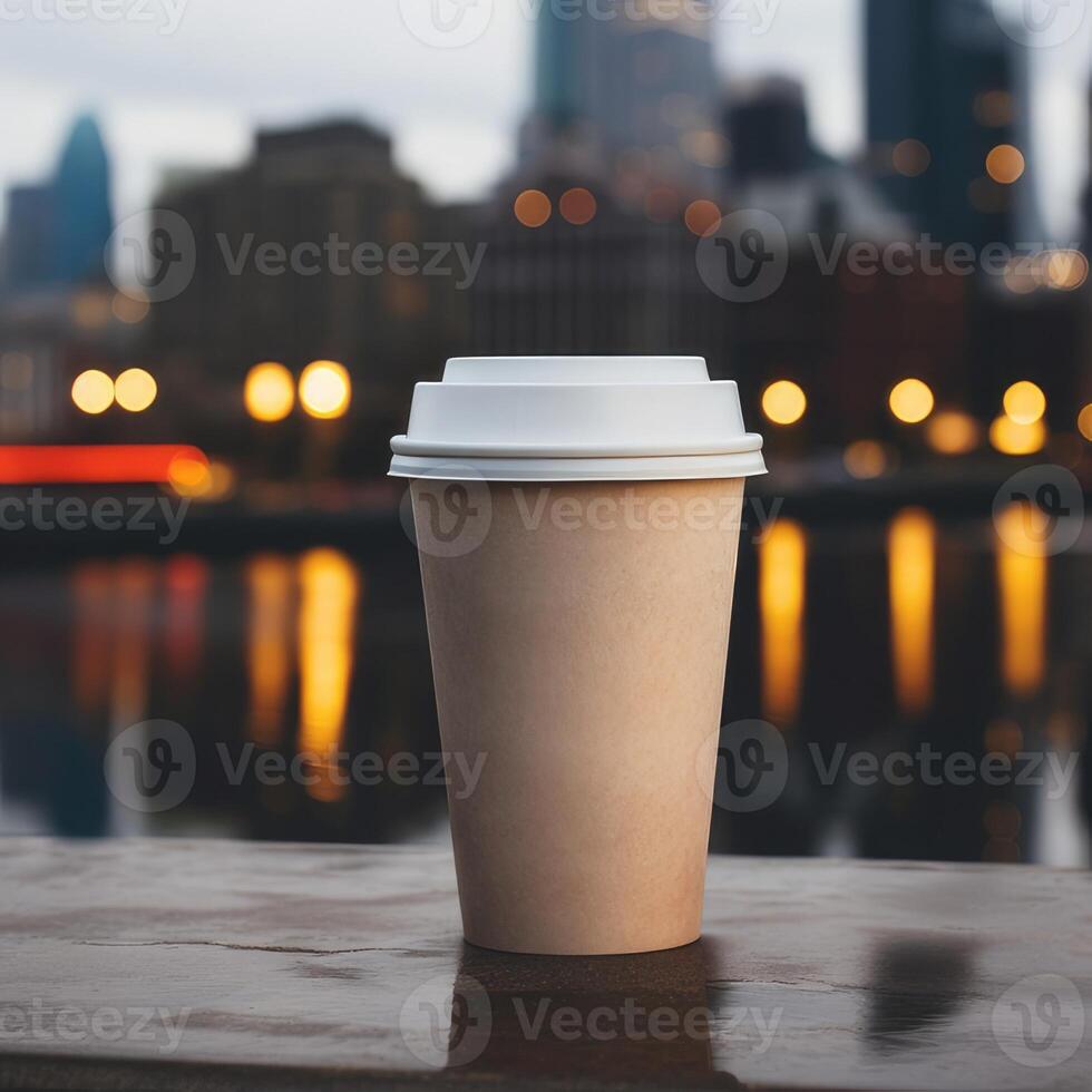 cardboard brown coffee cup without labels with a plastic lid on a blurred urban background with skyscrapers in the distance photo
