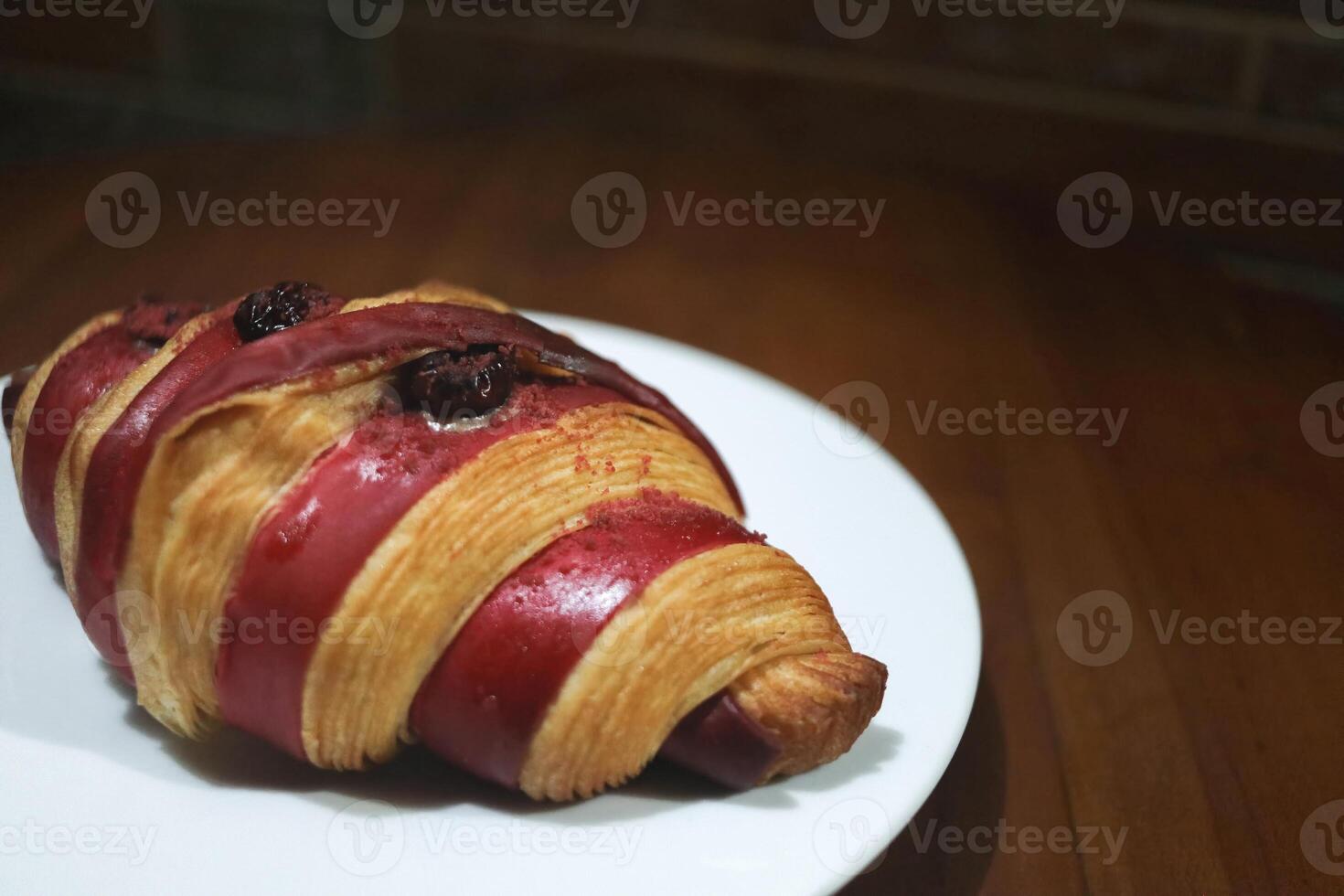 Freshly baked croissants with raspberry jam on a white plate on a wooden table. Healthy eating concept. Organic farm products for breakfast or lunch. photo