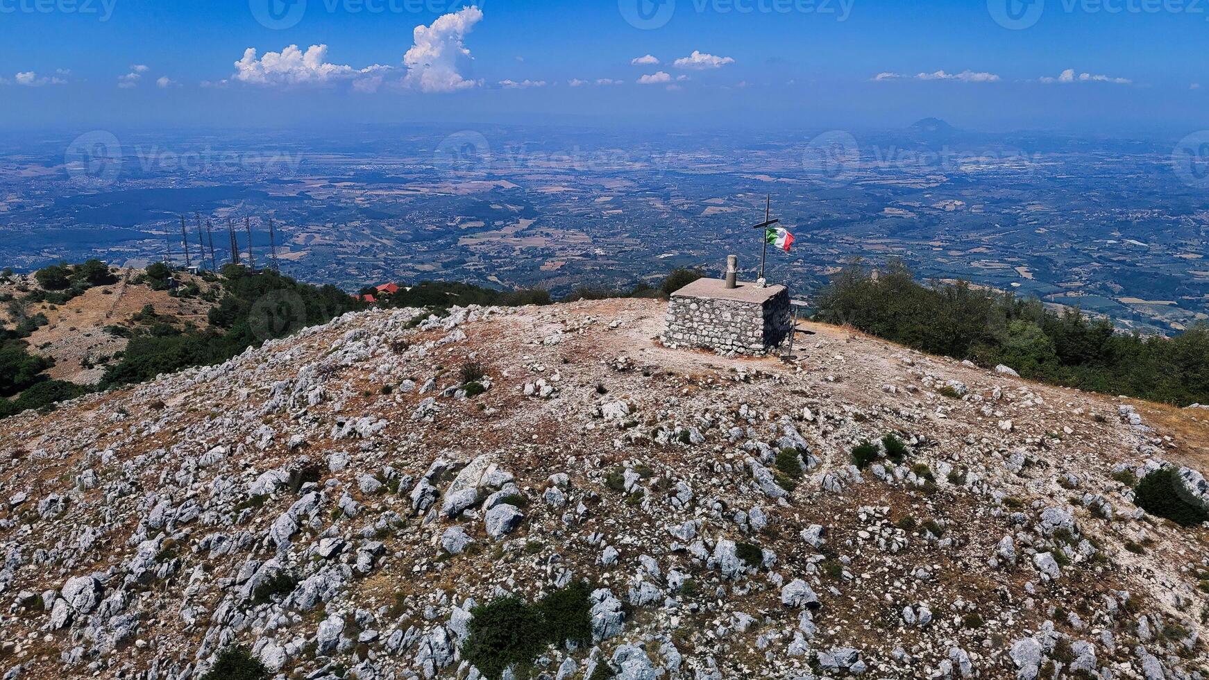 Italian flag waving on the top of a mountain with a breathtaking view photo
