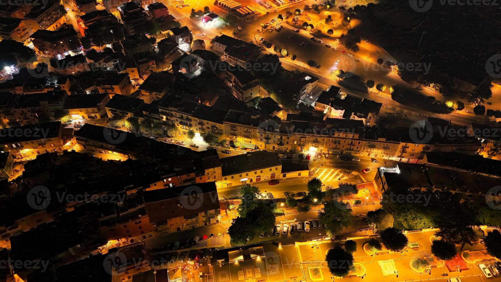 Drone capturing the magic of a small town bathed in the warm glow of street lights at night photo