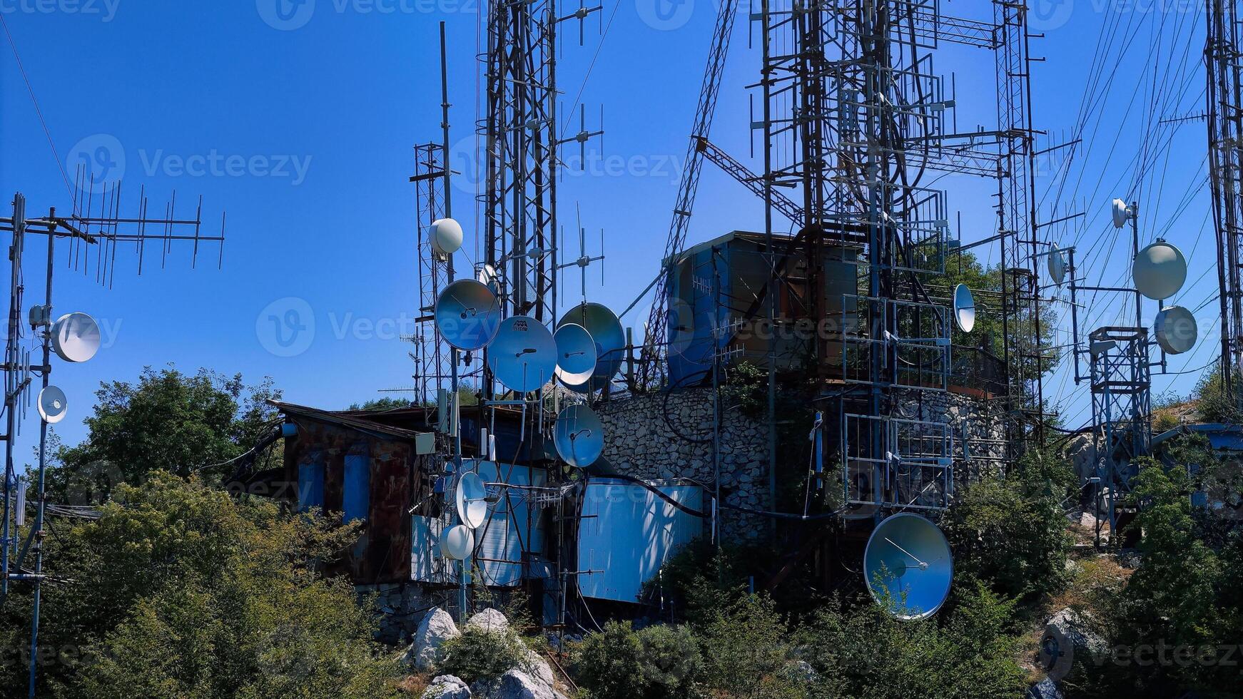Telecommunication antennas broadcasting signals from mountain top photo
