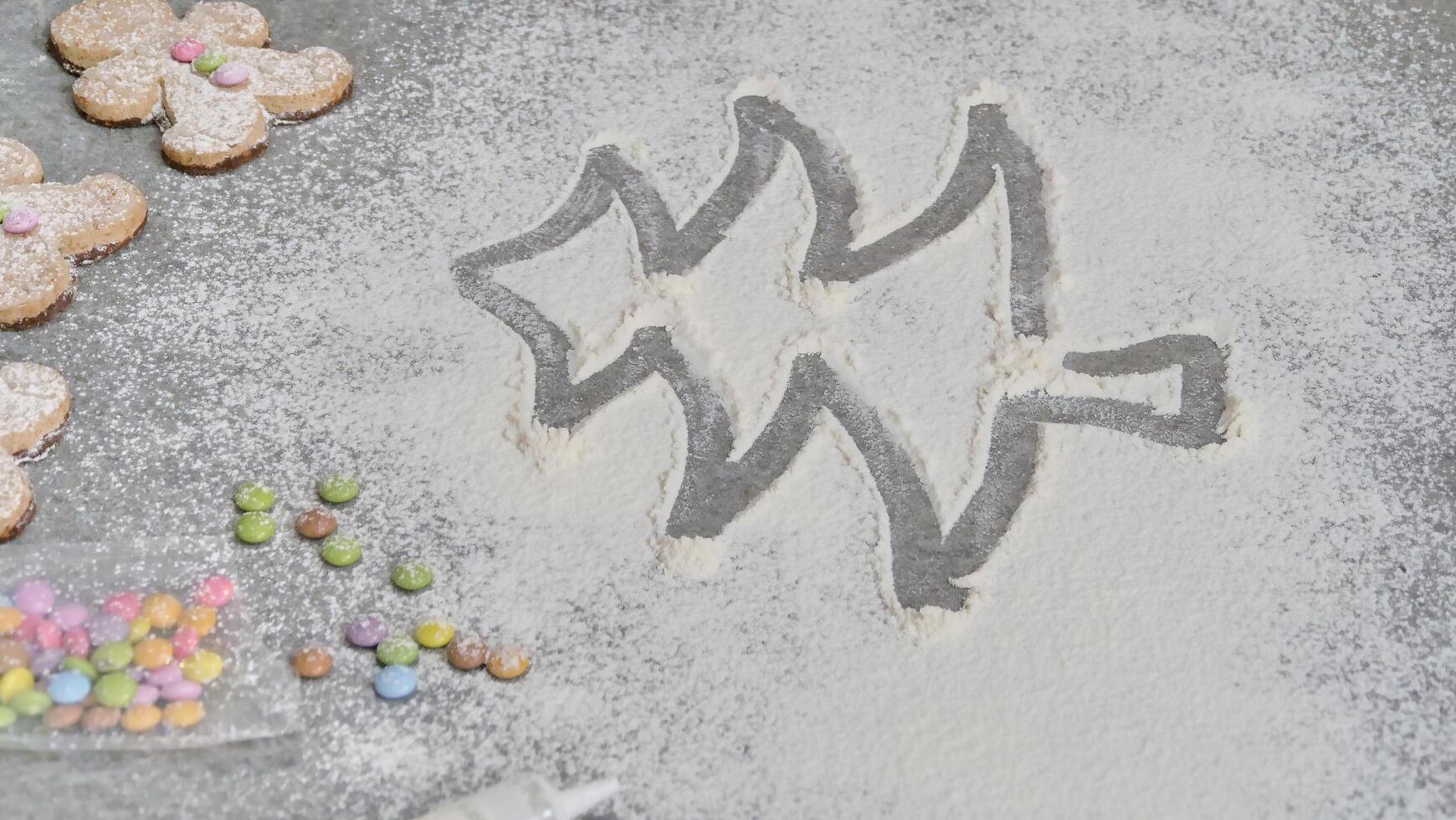 a child's hand draws a Christmas tree in flour photo