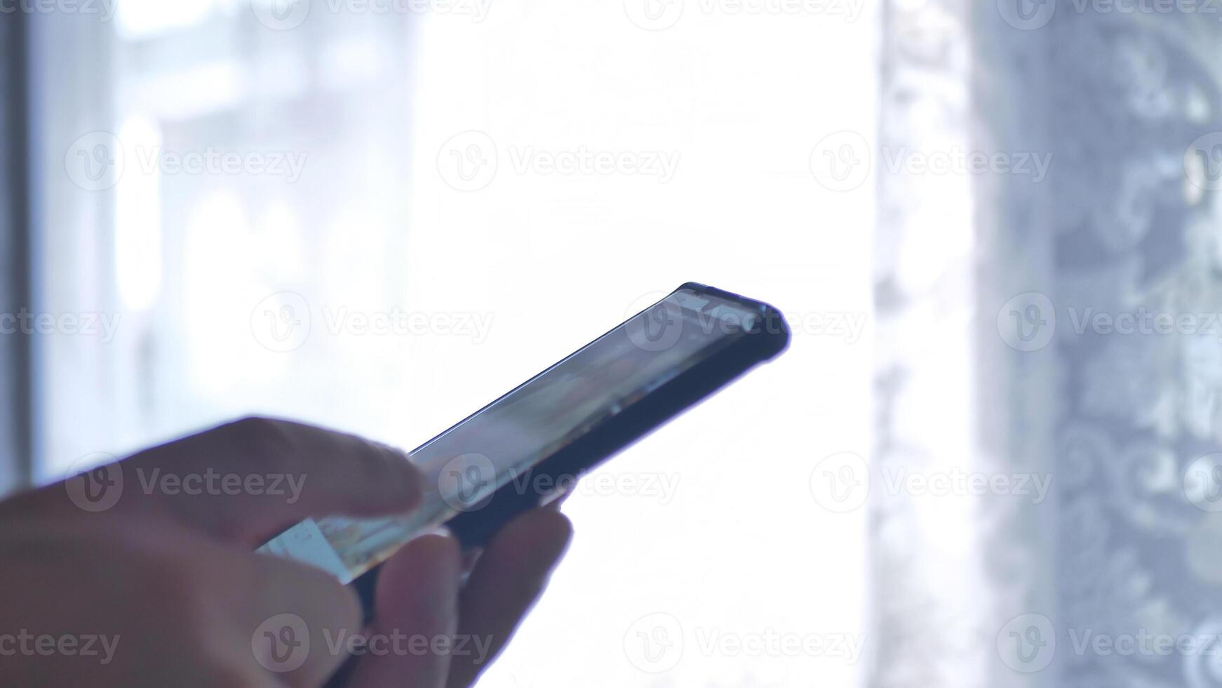 Young Man Look in Mobile Phone and Browse Social Network Close up photo