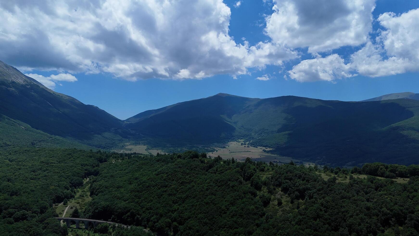 Breathtaking landscape of rolling hills and valleys beneath a dramatic sky in the heart of the countryside at midday photo