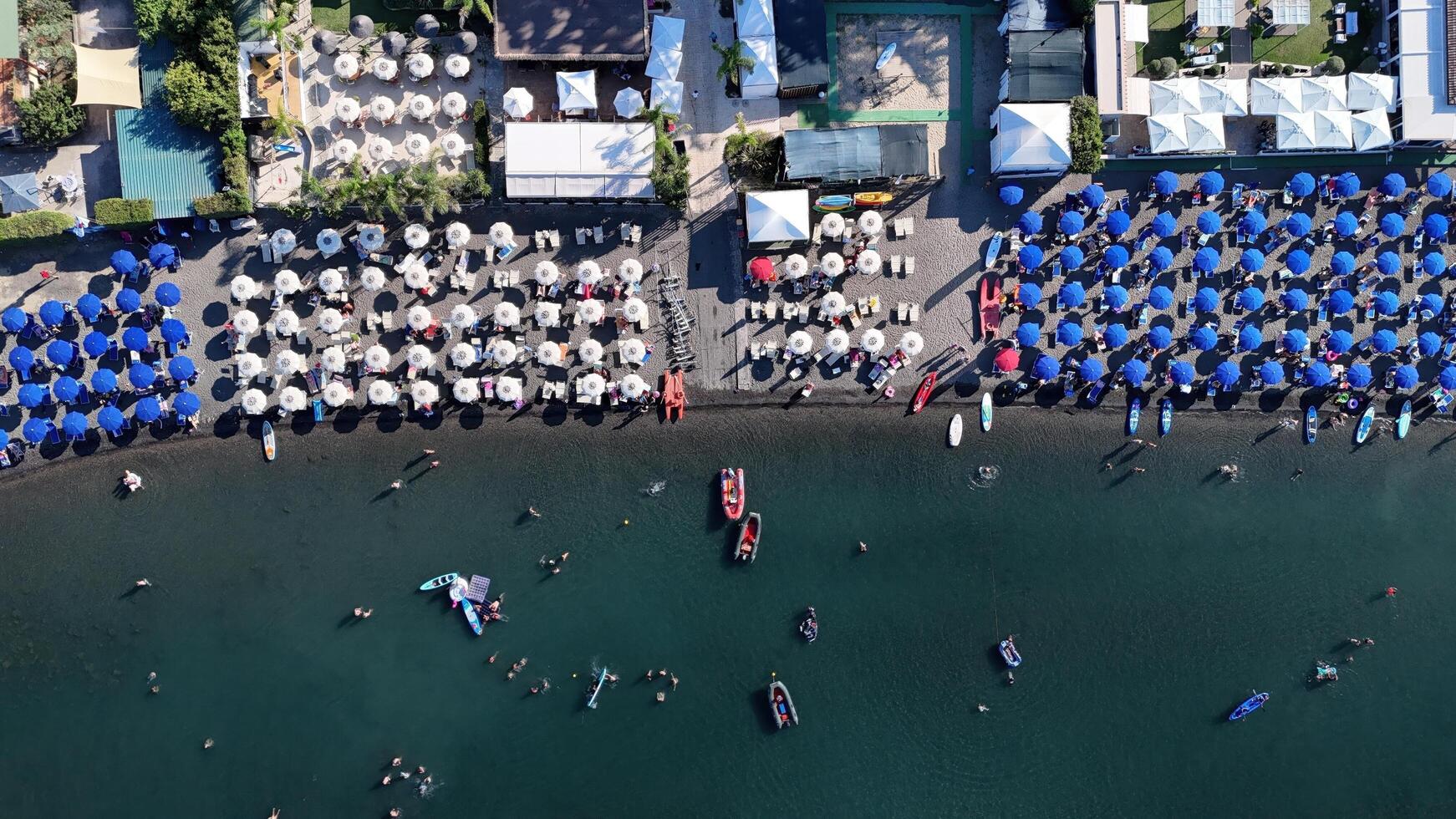 A vibrant summer day at the beach with colorful umbrellas and lively activities on the water in a popular coastal resort photo