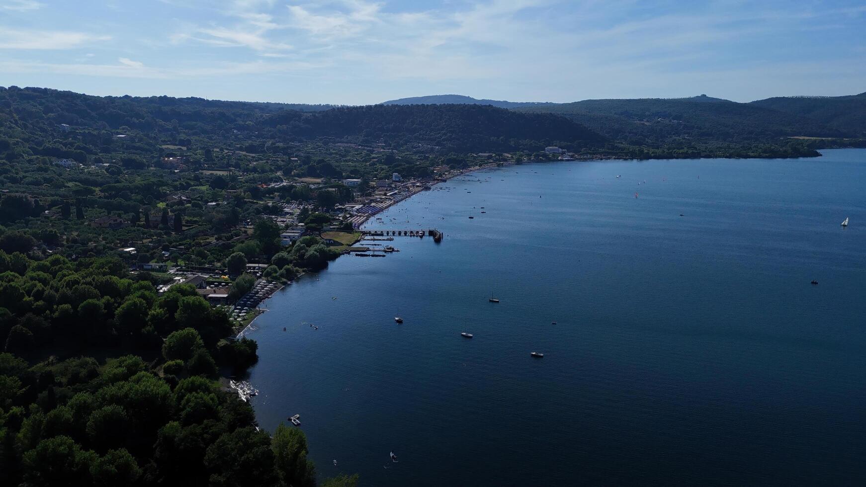 A serene lakeside view featuring boats and lush greenery under a clear blue sky on a sunny day in the countryside photo