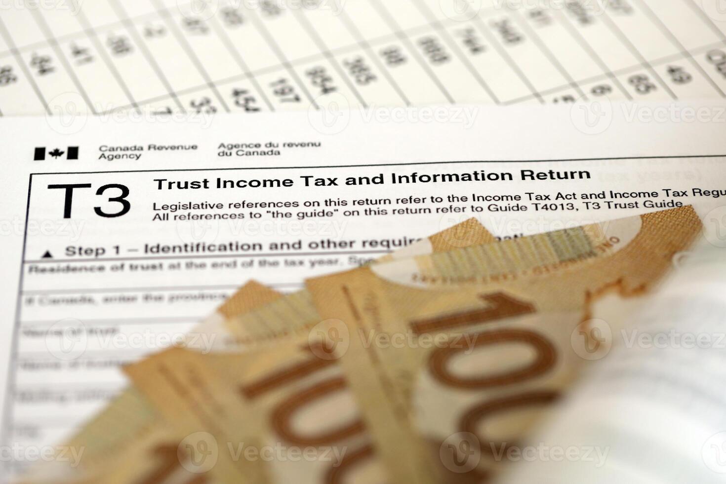 Canadian T3 tax form Trust income tax and information return lies on table with canadian money photo
