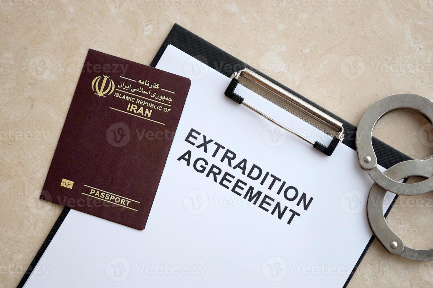 Passport of Iran and Extradition Agreement with handcuffs on table photo