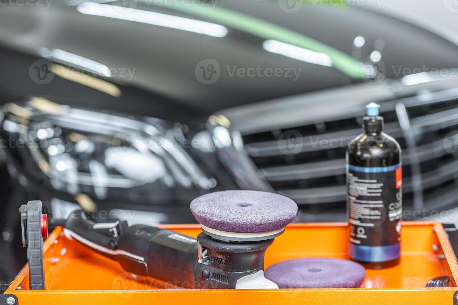 Detail to car detailing polisher and special wax from removing a scratches with luxury car on the background, car detailing concept photo
