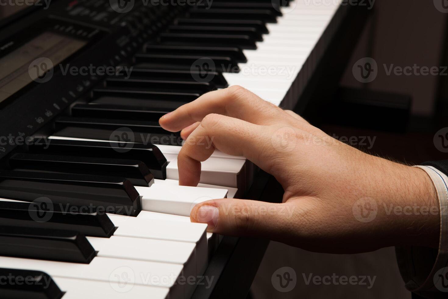 Piano keys and human hand photo