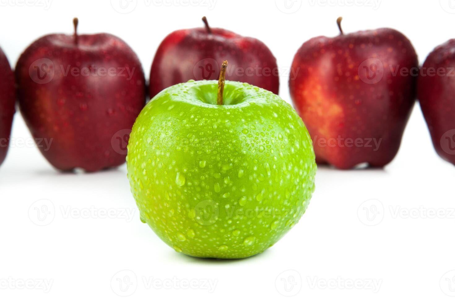 maroon apples lined up in a row and green apple closeup photo