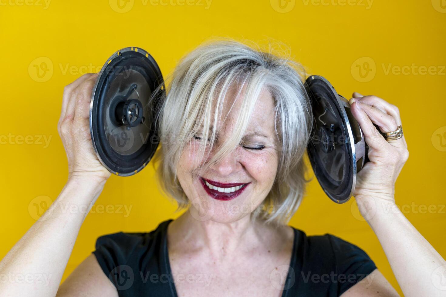 Funny portrait of mature woman. Beautiful lady having fun listening loud music photo
