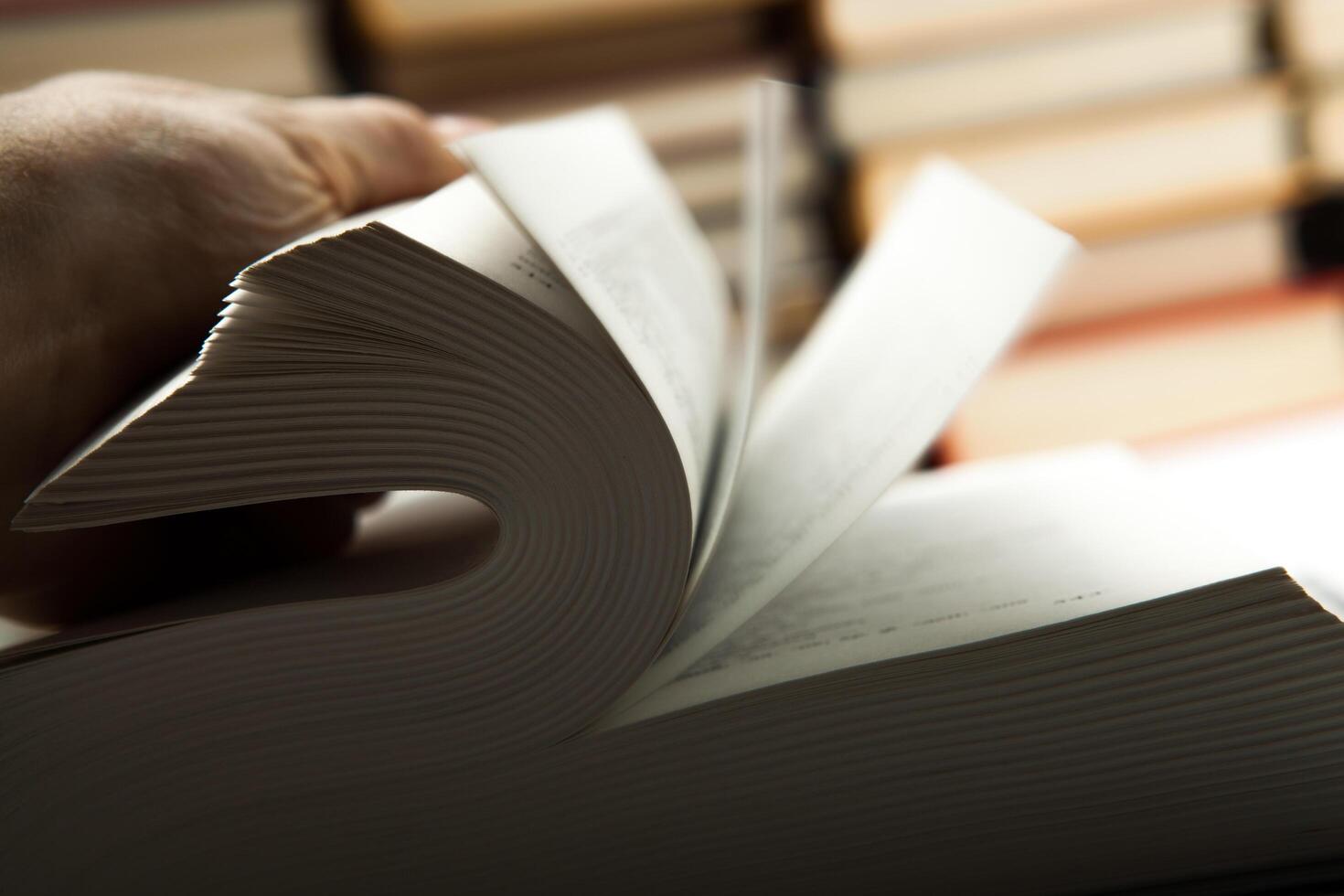 flipping book on with pile of books photo