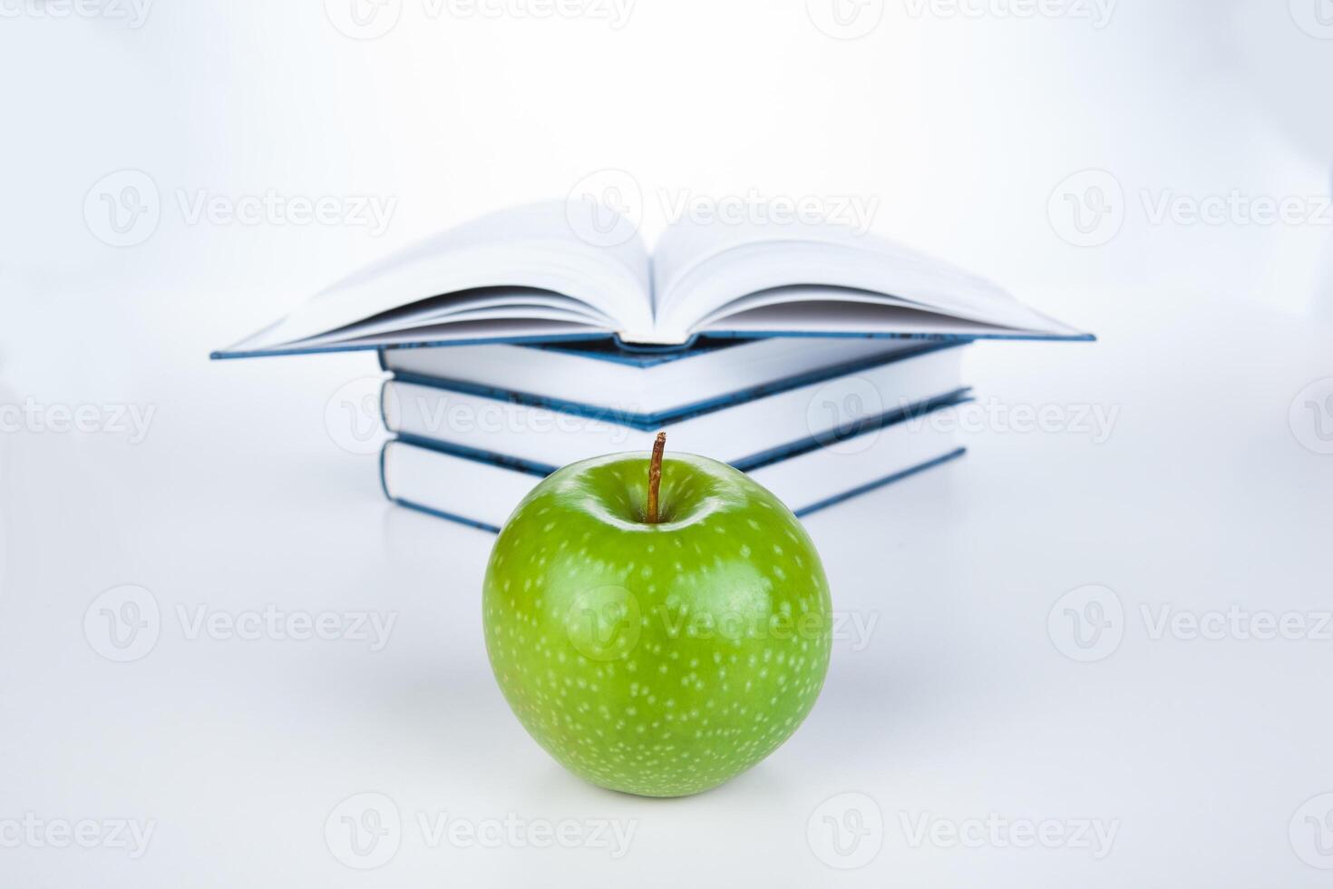 stack of books with green apple photo