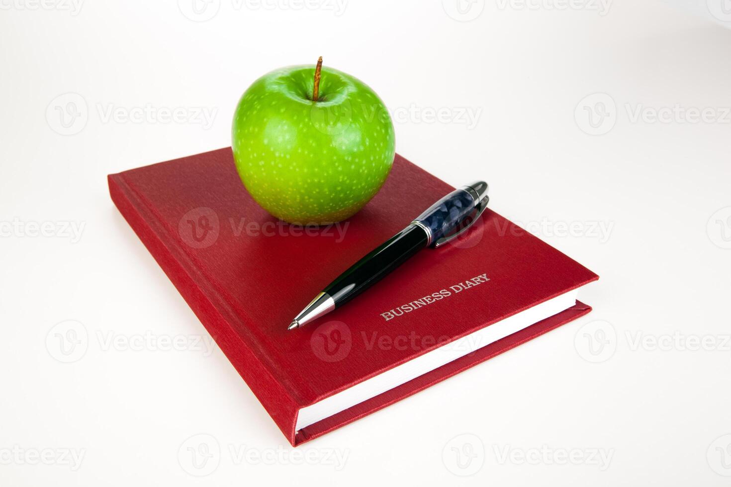 business diary with pen and green apple photo