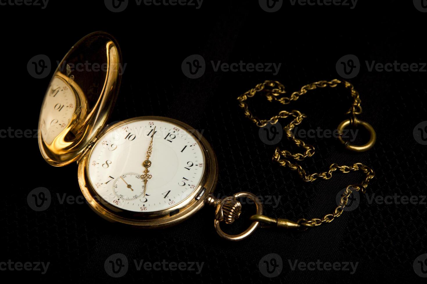 Gold pocket watch on black cloth photo