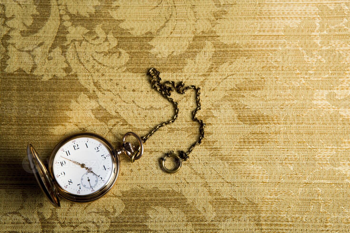 Gold pocket watch on gold cloth photo